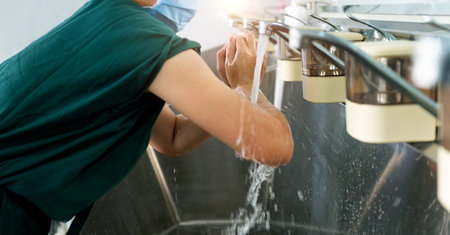 Young female doctor washing hands before operationの写真素材