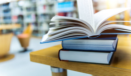 Stack of books opened on library deskの写真素材