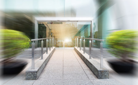 Modern office building with glass door, blurred motionの写真素材