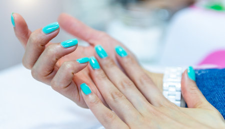 Beautiful female hands with blue manicure on nailsの写真素材