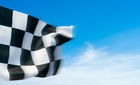 Closeup of checkered flag against blue skyの写真素材