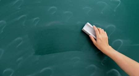 Woman's hand erasing question mark on chalkboardの写真素材