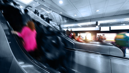 Many people rushing on the escalator in subway stationの写真素材