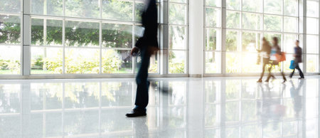 Group of business people walking in glass buildingの写真素材