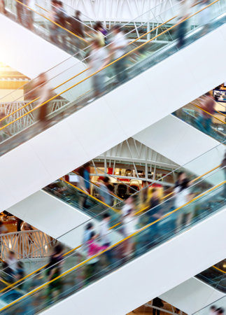 People on many fast moving escalators in modern shopping mallの写真素材