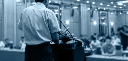 Business man making a speech in front of a big audienceの写真素材