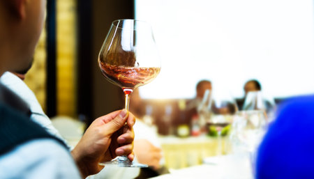 Unrecognizable man holding  glass of red wine at dinnerの写真素材