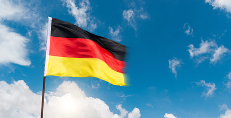 German flag waving against blue sky backgroundの写真素材