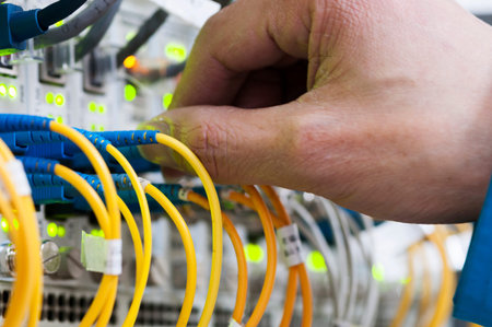 Man connecting network cables to switches