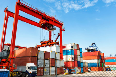 Pier under the blue sky, cranes and containers.