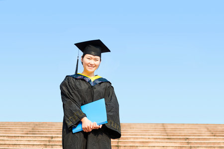 Beautiful female graduate wearing a graduation gownの写真素材