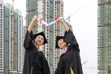 Beautiful female graduates wearing a graduation gownの写真素材