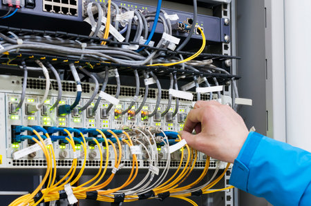 Man connecting network cables to switches