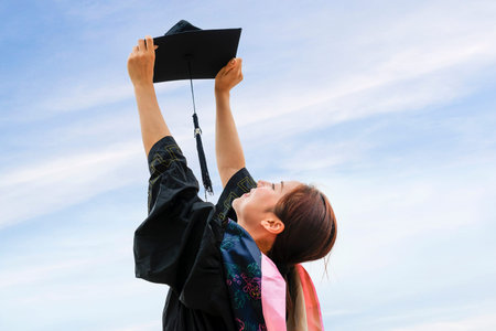 Beautiful female graduate wearing graduation gownの写真素材