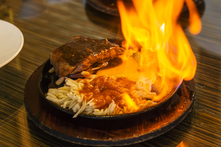 beef steak on the iron plate with flames.の写真素材
