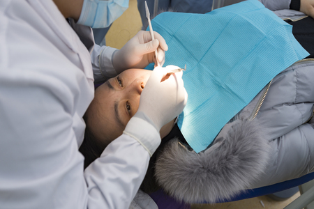 Dentist curing a female patientの写真素材