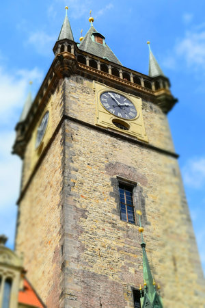 The clock tower of Old Town Hall in Prague in Czech Republic, with blue sky and white clouds in the...