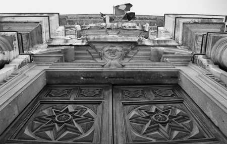 An ancient monumental wooden door in a marble palace with columns. Black and white.のeditorial素材