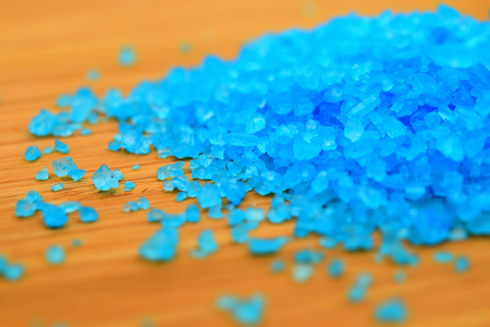 Turquoise bath salts on wood background. Tilt-shift effect applied.の写真素材
