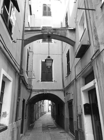 A traditional stone alley between houses with arc in Ceriale, Liguria, in Italy. Black and white.の写真素材