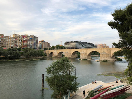The Ebro river and the old Stone Bridge of Zaragoza in Spain, in a cloudy day