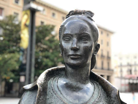 Close up of a statue face of a Spanish young woman in dark stone with traditional dressのeditorial素材