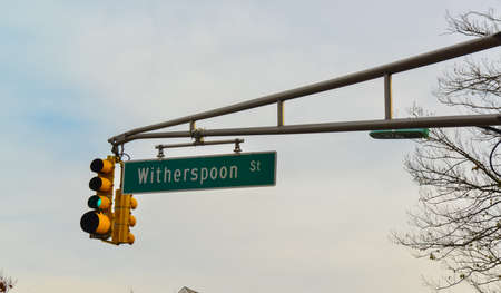 PRINCETON, NJ USA - NOVENBER 12, 2019: Yellow traffic light with street sign "Witherspoon st." on Princeton Central Street, opposite Princeton University entrance, NJ USAのeditorial素材