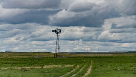 Small old wind turbine in a field against a cloudy sky in Tennessee, USAの写真素材