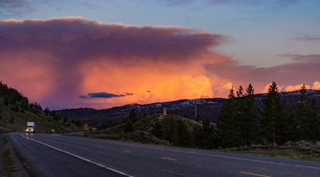 A beautiful red sunset over the mountains overgrown with coniferous forest. USAの写真素材