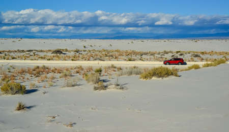 USA, NEW MEXICO - NOVEMBER 23, 2019: red car rides the harms of sand dunes from gypsum to White Sands National Monument, New Mexico, USAのeditorial素材