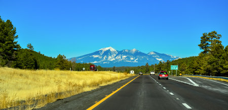 ARIZONA, USA - NOVEMBER 25, 2019: two-lane road with cars, picturesque mountains with snow caps on the horizon in Arizonaのeditorial素材