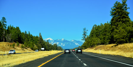 ARIZONA, USA - NOVEMBER 25, 2019: two-lane road with cars, picturesque mountains with snow caps on the horizon in Arizonaのeditorial素材