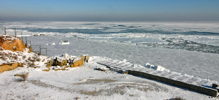 The Black Sea is frozen, ice floes float along the shore. climate change, harsh winter