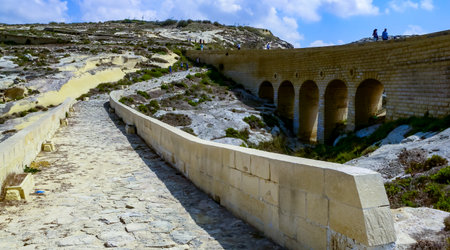 DWEJRA, GOZO, MALTA - SEPTEMBER 14, 2012: An arched bridge road built with globigerina limestone stones like an aqueduct crossing the valleyのeditorial素材