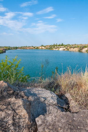 View of the flooded granite quarry with turquoise clear water, Ukraineの写真素材