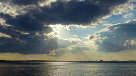 Rays of the sun in dark thunderclouds before rain over the Kuyalnitsky estuary, southern Ukraineの写真素材