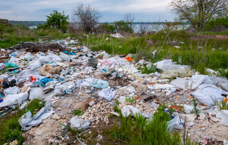 ODESSA region, UKRAINE - APRIL 30, 2017: Heaps of plastic trash on the shore of the reservoir. Ecology of nature, unorganized garbage dumpの写真素材