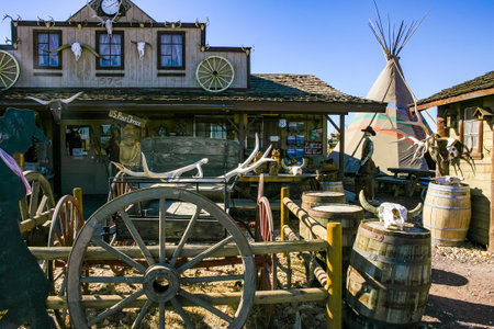 Arizona, USA - November 27, 2009: Rustic wooden saloon flanked by a traditional teepee and vintage...
