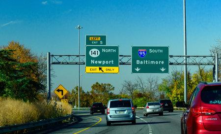 Delaware, USA - November 02, 2025: a highway signage located along Interstate 95 in Delaware. The green sign on the left indicates a left-hand exit for Delaware Route 141 North toward Newport. The sign on the right directs traffic to continue on Interstat