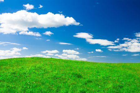 Green hill under blue cloudy skyの写真素材