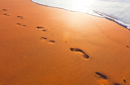 beach, wave and footsteps at sunset timeの写真素材