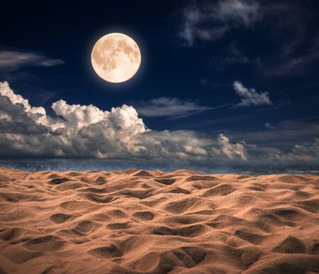 Sandy beach and moon at nightの写真素材