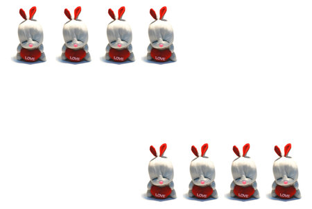 Rabbit sits and holds in paws red heart a symbol of loveの写真素材