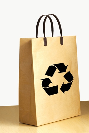 Recycle logo on paper bag on wooden floor against the white wall の写真素材