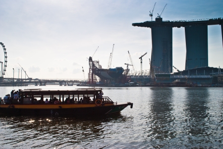 boat crossing in front of Merlion landmarkのeditorial素材
