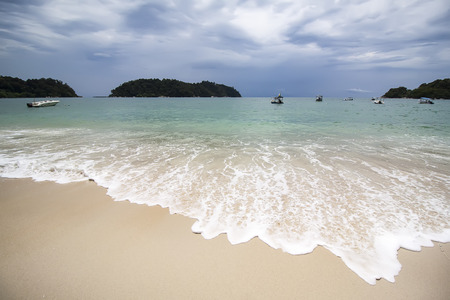 small wave hitting sand on the beachの写真素材
