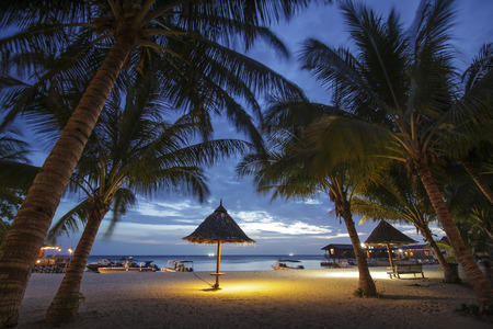 small tropical hut on white sand at nightの写真素材