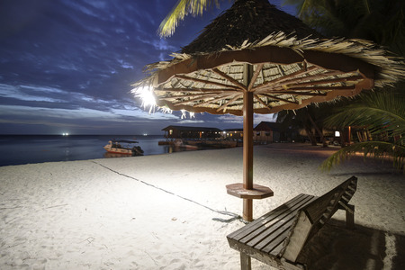 small tropical hut on white sand at nightの写真素材