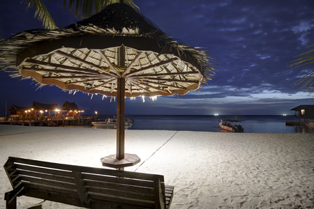small tropical hut on white sand at nightの写真素材