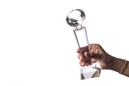 glass trophy hold by a female figureの写真素材